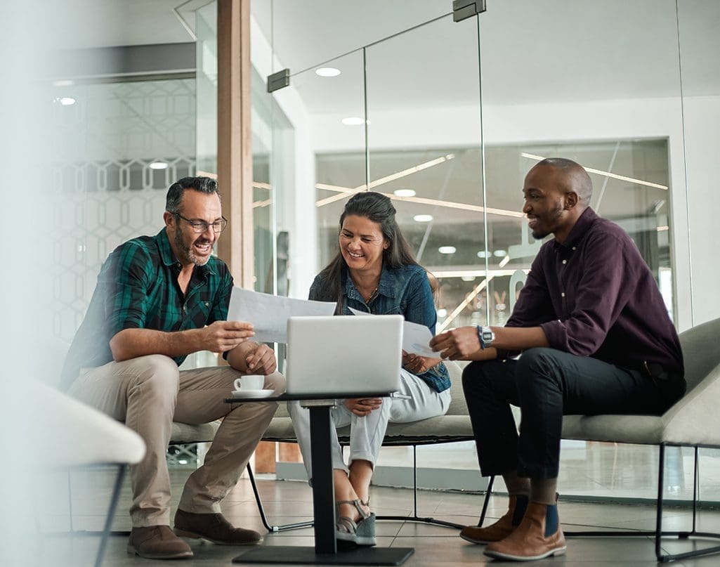 Casual meeting of smiling diverse business team analyzing financial data