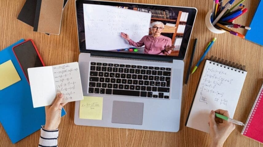 High angle view of video conference with teacher on laptop at home. College student learning maths while watching online webinar, listening audio course. Top view of girl in video call with personal tutor on computer, distance and e-learning education concept.