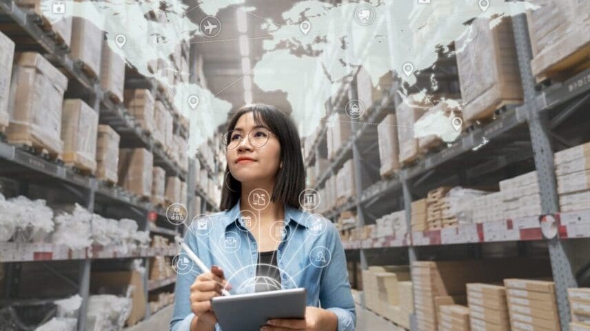 Portrait of happy young attractive asian entrepreneur woman looking at inventory in warehouse using smart tablet in management technology, interconnected industry, asian small business sme concept.