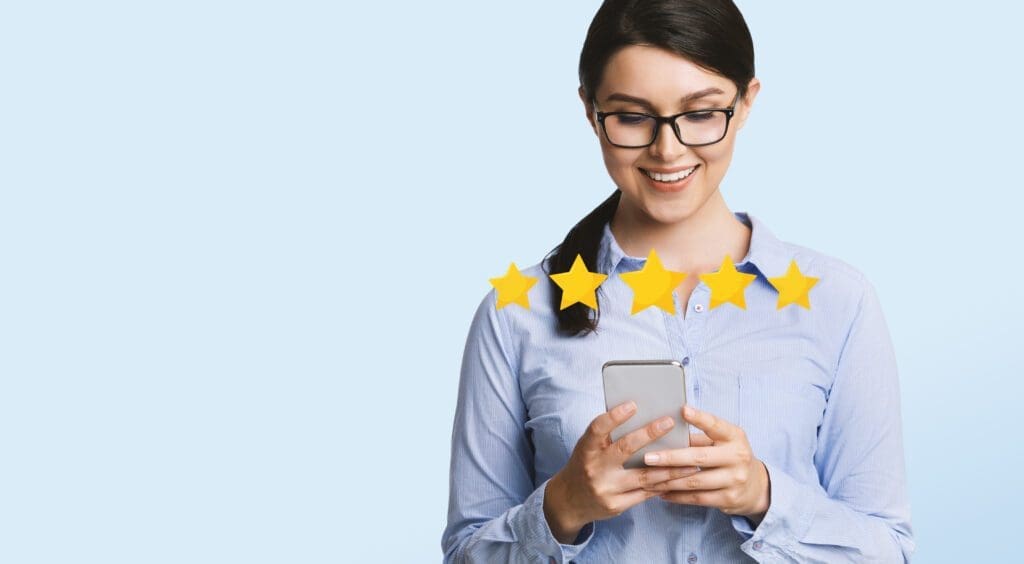 Business App Rating. Happy Millennial Businesswoman Evaluating Mobile Application On Smartphone With Five Stars, Light Studio Background, Panorama