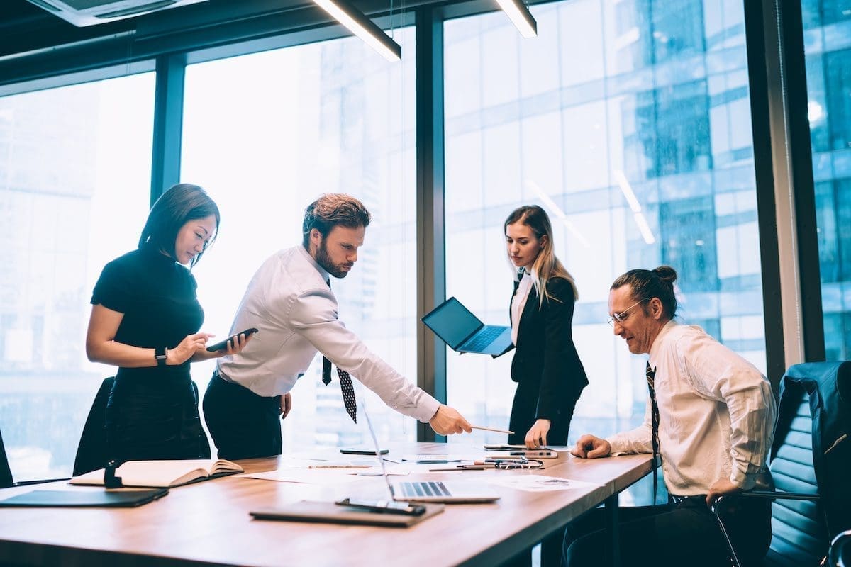 Office workers discussing capturing enterprise software requirements.