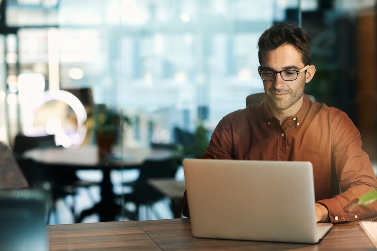 Businessman working online with a laptop to automate the rfp creation process using rfp automation software